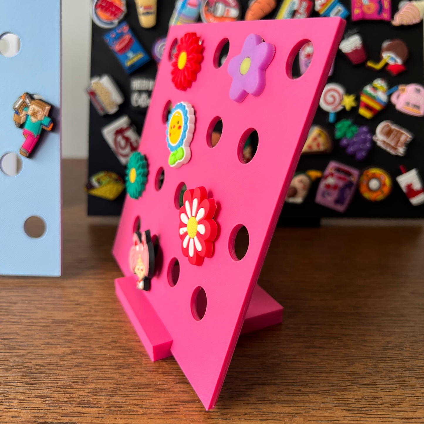 Bright pink display stand showcasing colorful charms in flower shapes, adding whimsy to any collection.