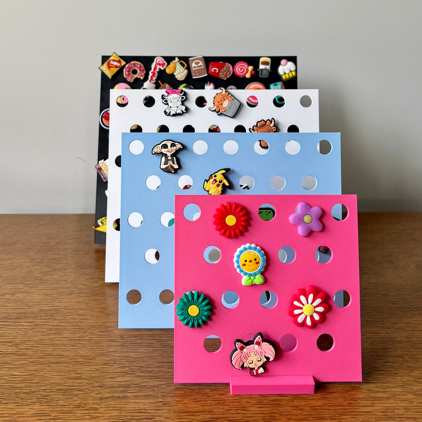 Colorful display stands showcase various whimsical charms on a wooden surface, emphasizing creativity and personalization.
