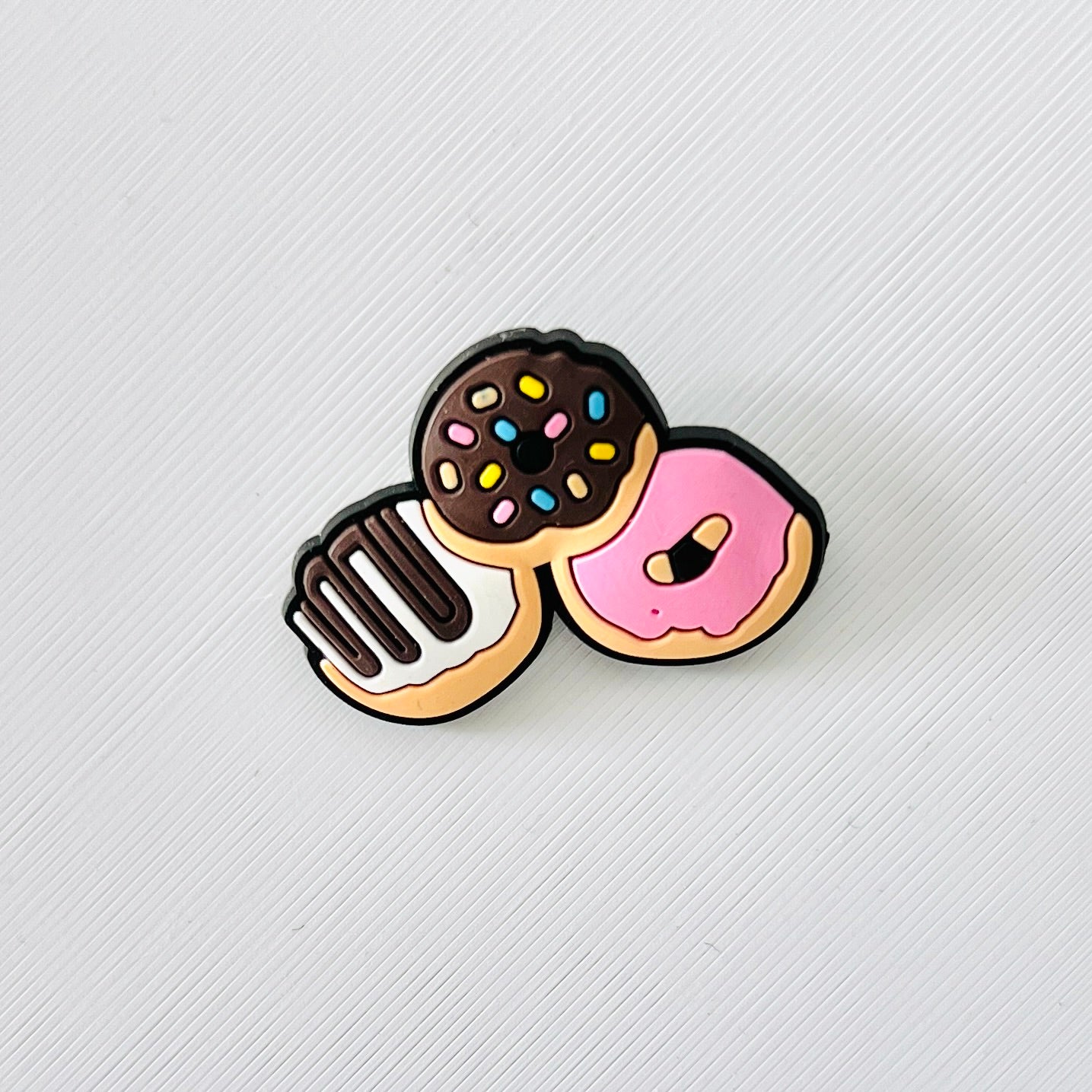 Adorable shoe charm featuring three colorful mini donuts with sprinkles and icing, perfect for personalized footwear.