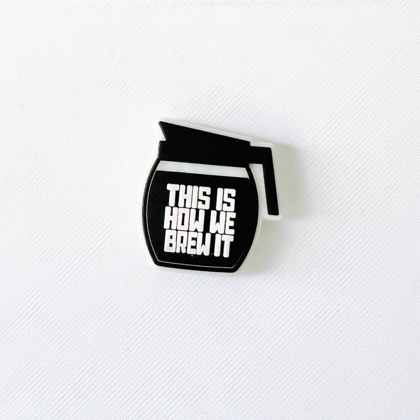 Black coffee brew pot charm with bold "This Is How We Brew It" text, perfect for coffee lovers and baristas.