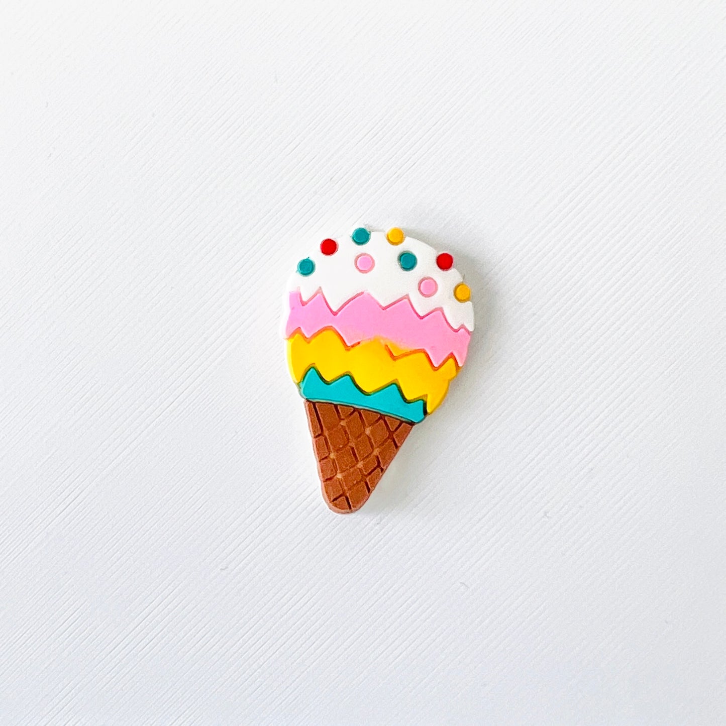 Colorful ice cream cone charm with blue, yellow, pink, and white scoops topped with sprinkles, perfect for fun footwear!