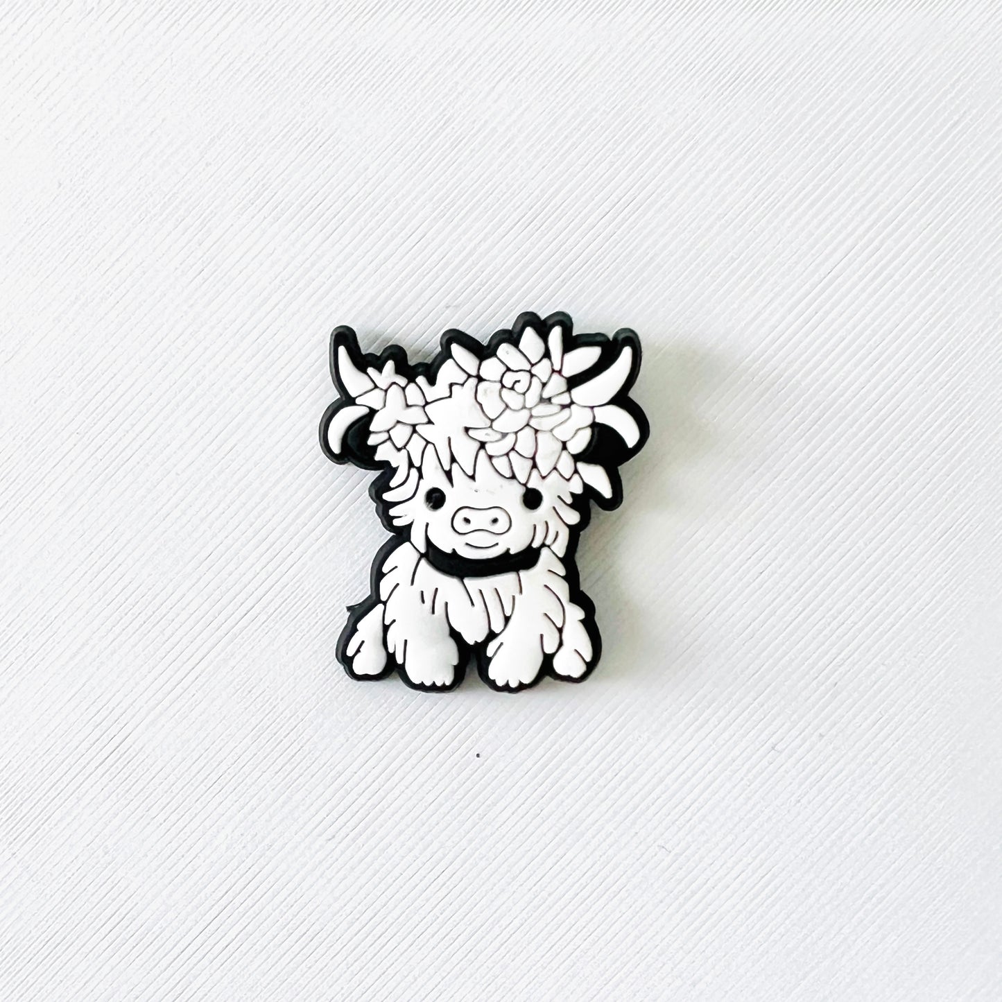 Adorable white Highland cow with flower accents, perfect for adding charm to clog-style shoes or as a gift for nature lovers.