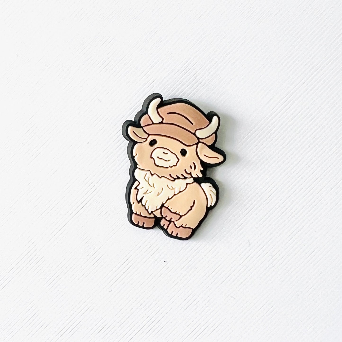 Fluffy Highland cow with a cap, perfect for adding a fun touch to your shoes and great for cow lovers.