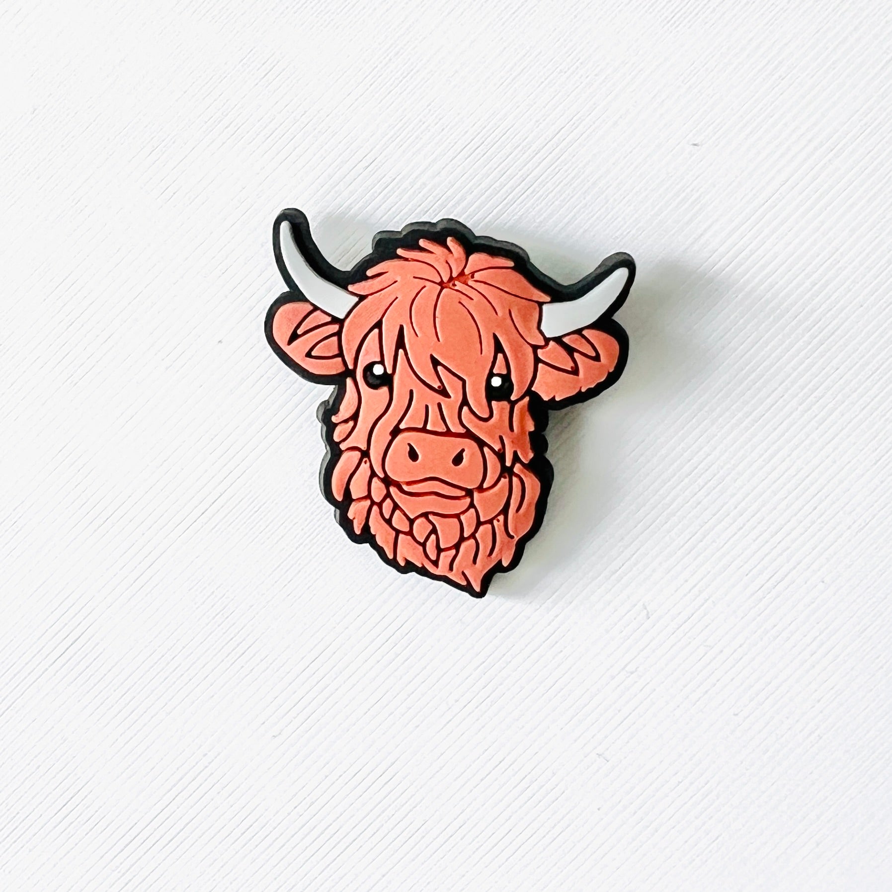 Adorable brown Highland cow face charm with fluffy features and gentle expression, perfect for adding charm to shoes.