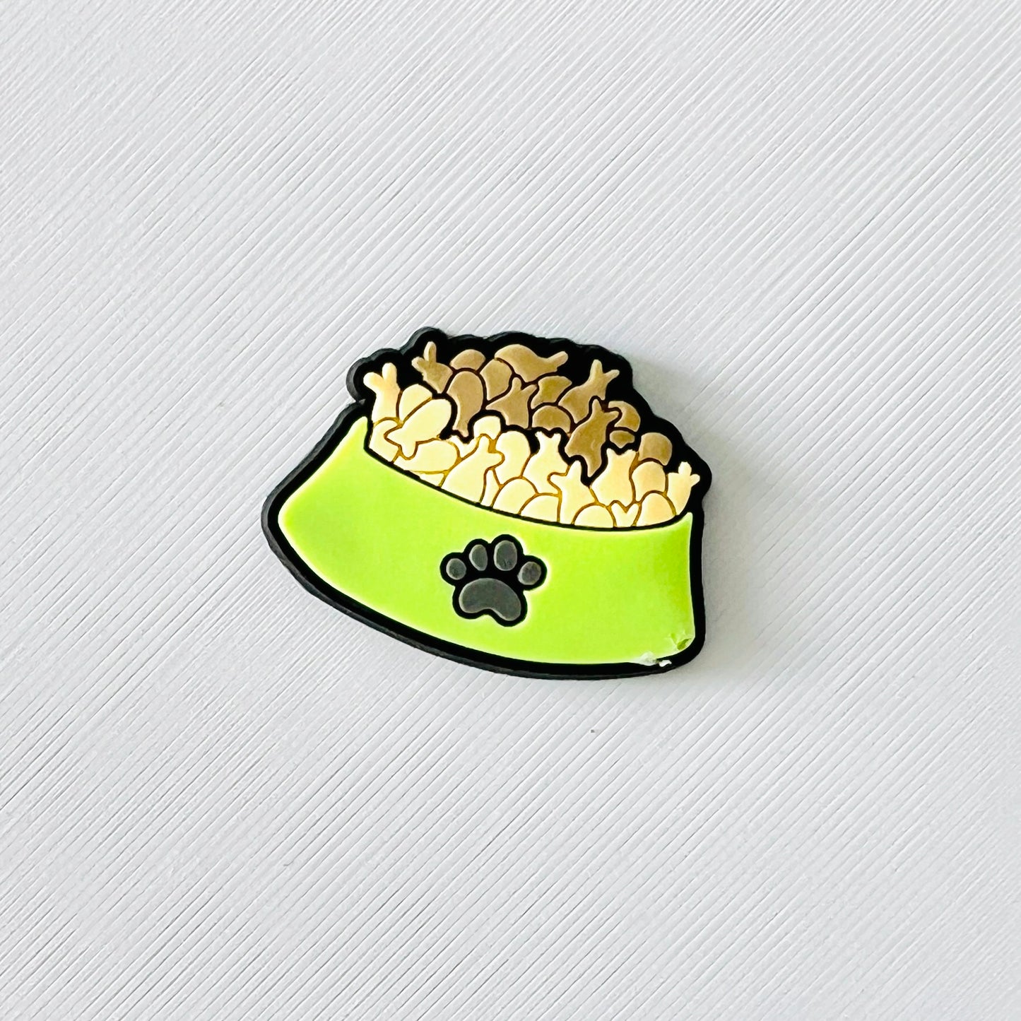Charming green bowl filled with fish-shaped biscuits, featuring a cute paw print, perfect for adding flair to shoes.