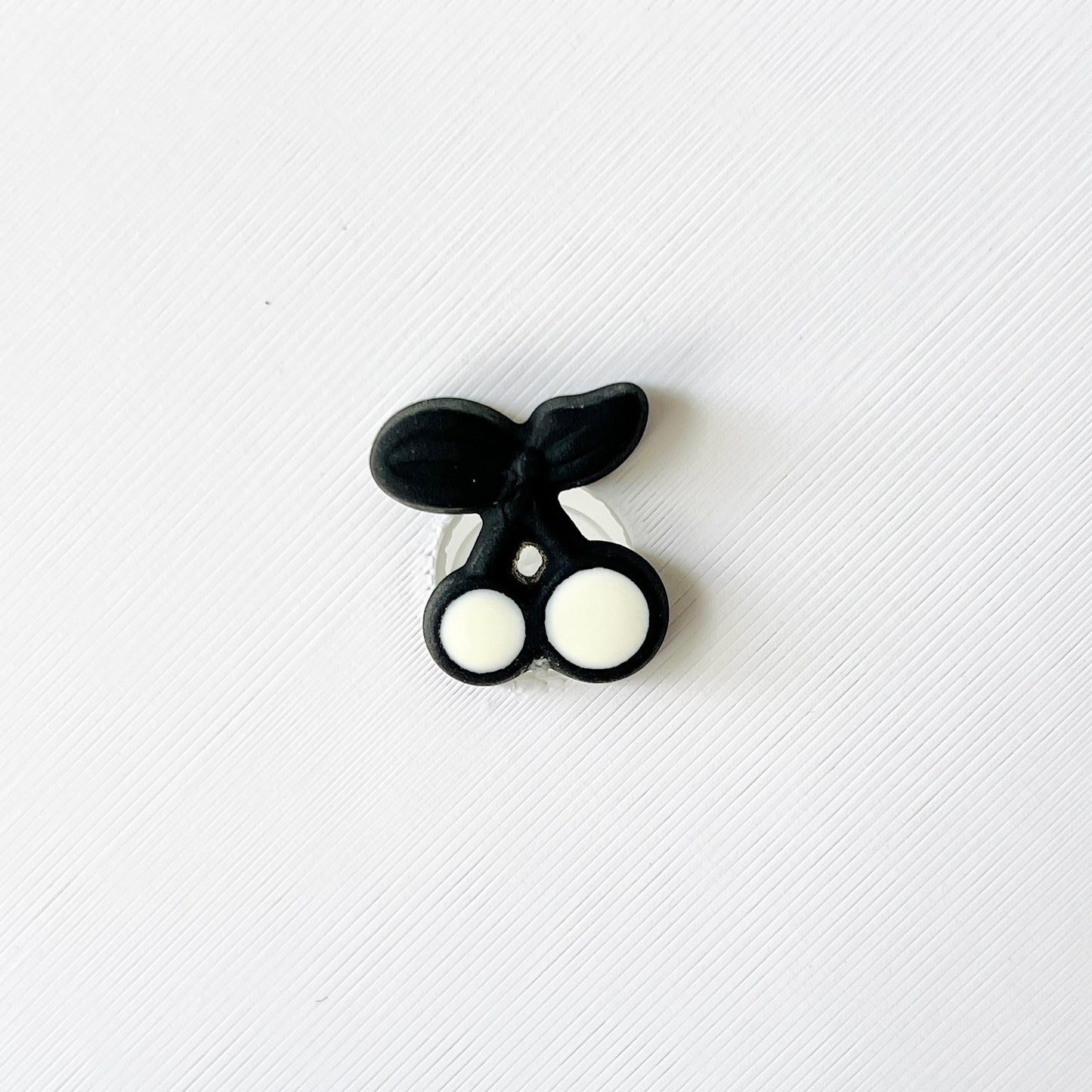 Black and white cherries charm with a sleek design, perfect for adding flair to shoes. Ideal for retro and fruit lovers.