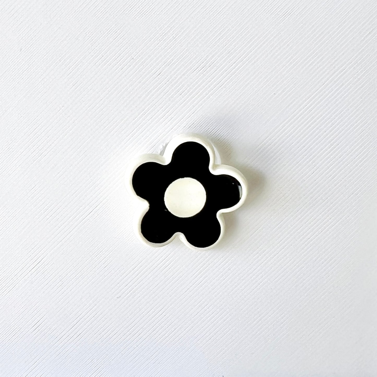 Chic black and white flower charm features a glossy finish, perfect for adding elegance to shoes with a classic touch.