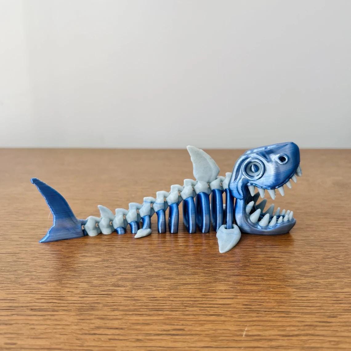 Blue and white skeleton shark figurine showcasing intricate details, perfect for ocean-themed decor enthusiasts.