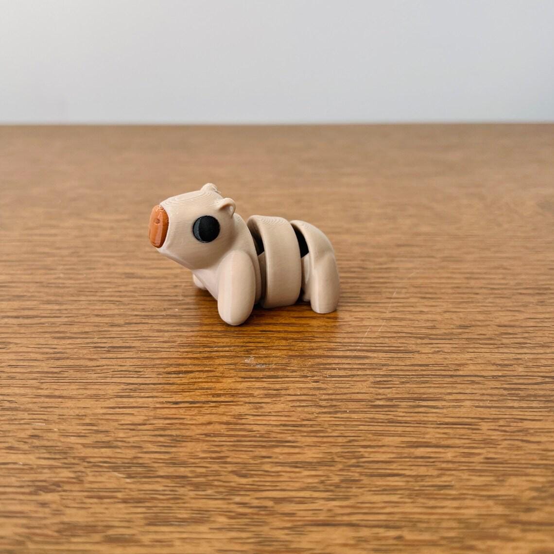 Adorable articulated capybara in soft tan colors, featuring black eyes and a brown snout, perfect for sensory play.