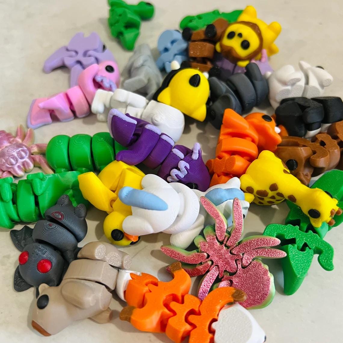 Colorful micro-sized fidget figures in various animal and food shapes, featuring unique color combinations and flexible desig