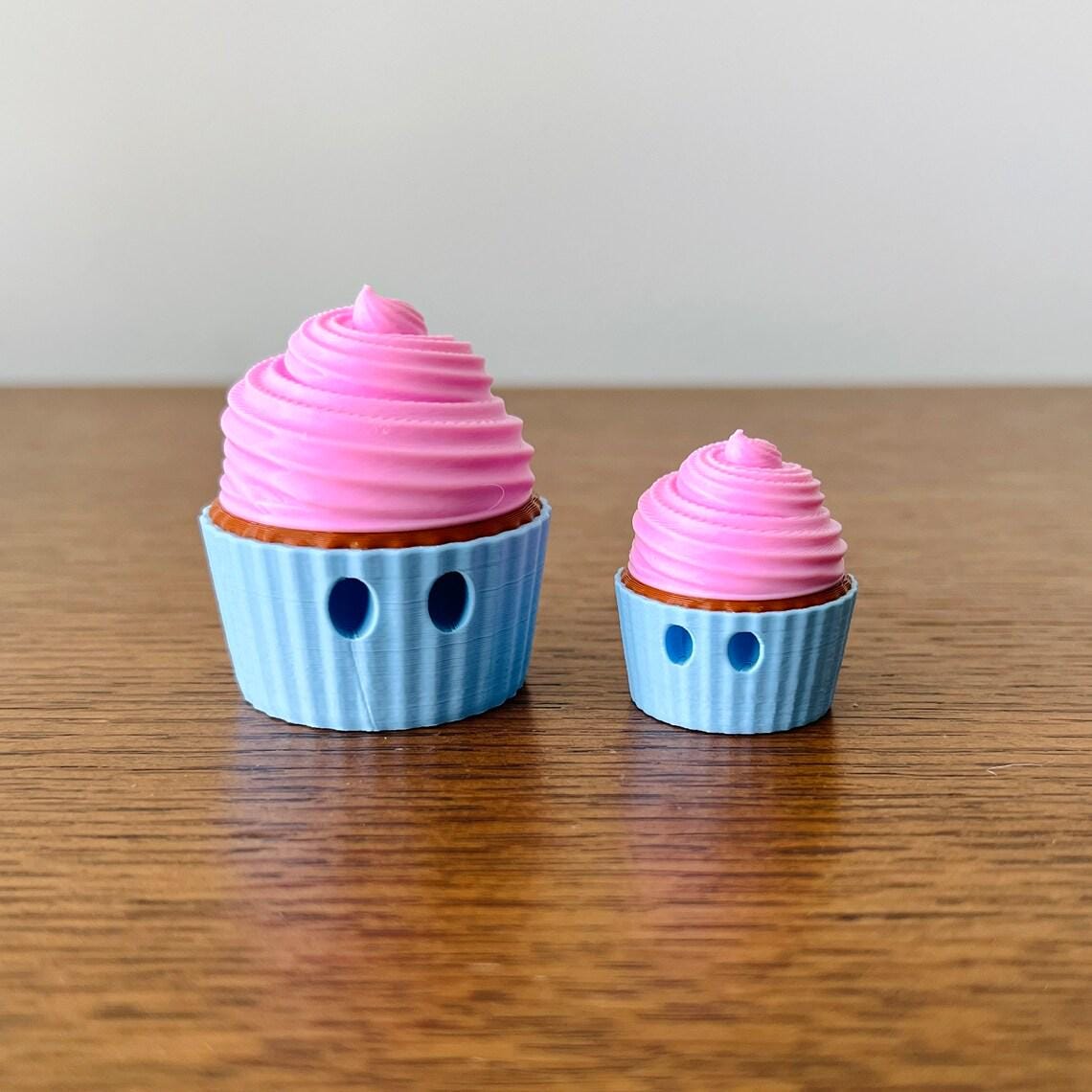 Adorable 3D printed mini chocolate cupcakes with playful eyes and pastel pink frosting, perfect for sensory fun.