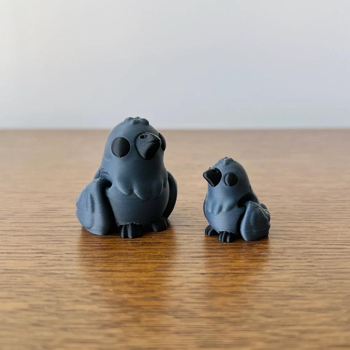 Articulated black crows in two sizes, showcasing a sleek, minimalist design on a wooden surface.