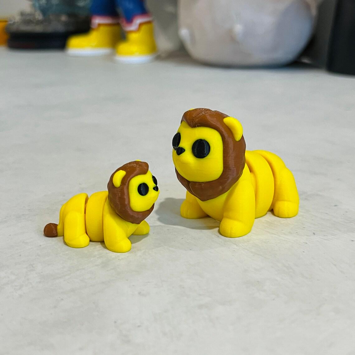 Two adorable, articulated lions in vibrant yellow with brown manes, perfect for sensory play and stress relief.