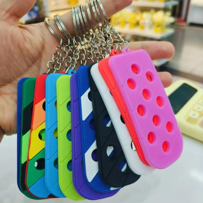Colorful silicone keychains in various shades, featuring holes for customizable shoe charms, held in a hand.