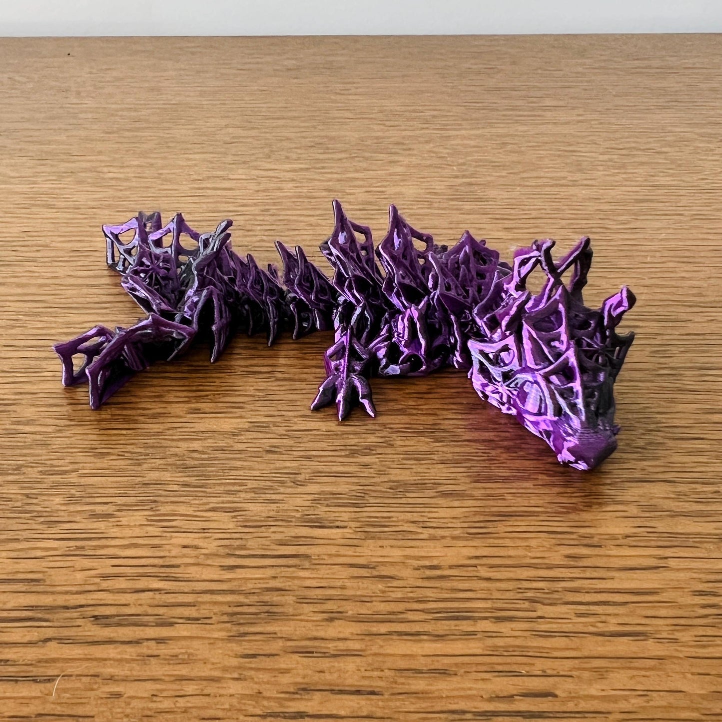 Fierce purple dragon with an articulated body, featuring intricate textures and a striking, whimsical design.