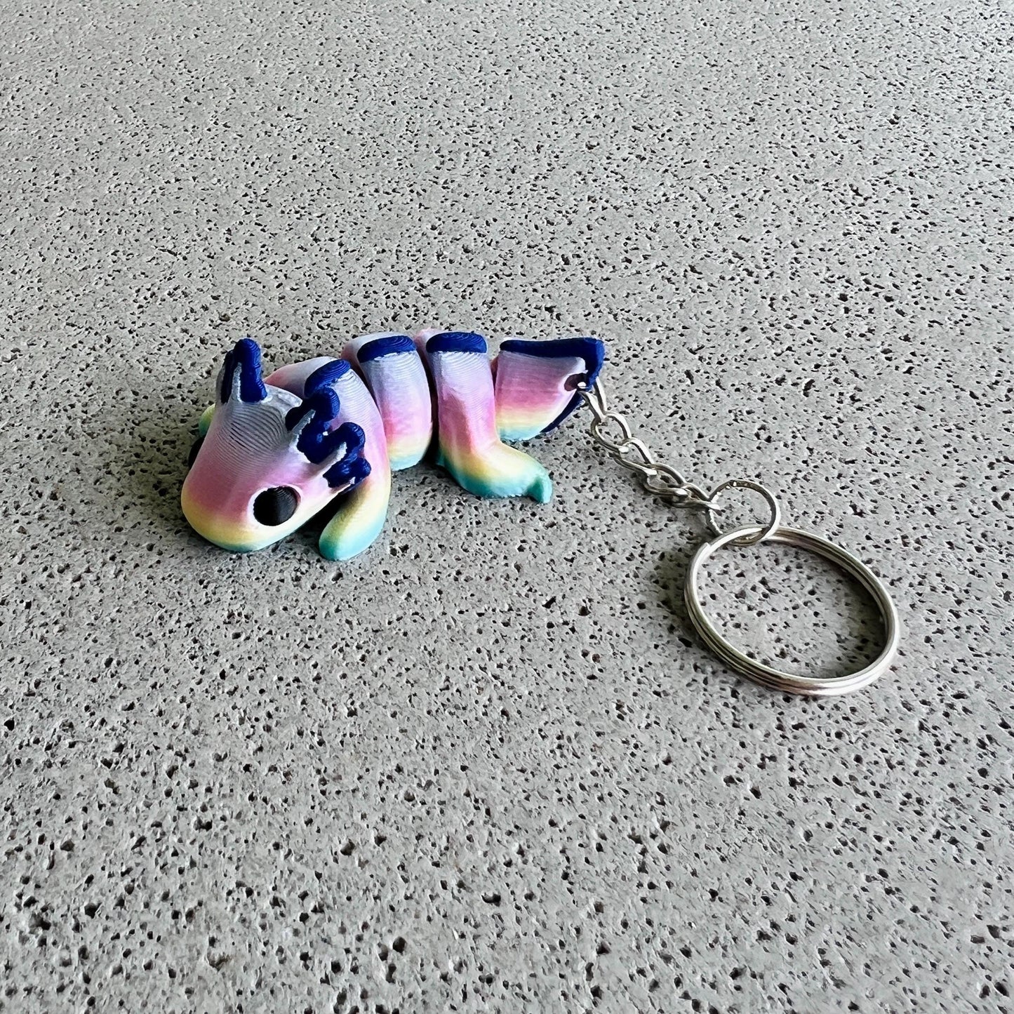 Vibrant rainbow axolotl keychain with colorful body and playful features, perfect for adding flair to bags or keys.