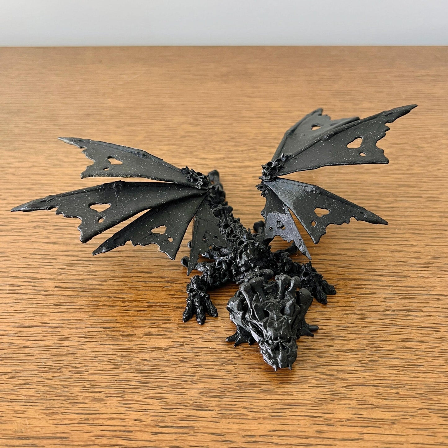 A haunting black dragon with skull-like features and intricately hollow wings, exuding an edgy, mystical vibe.