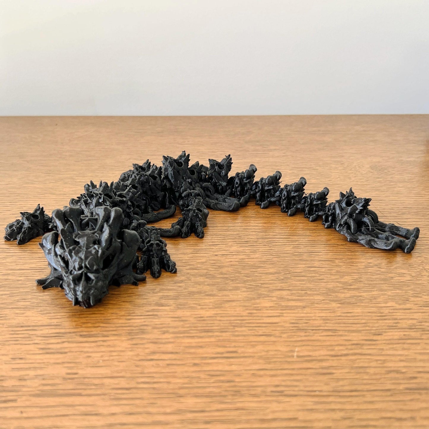 A unique skull-like baby dragon with intricate details, exuding mystery and charm, resting on a wooden surface.