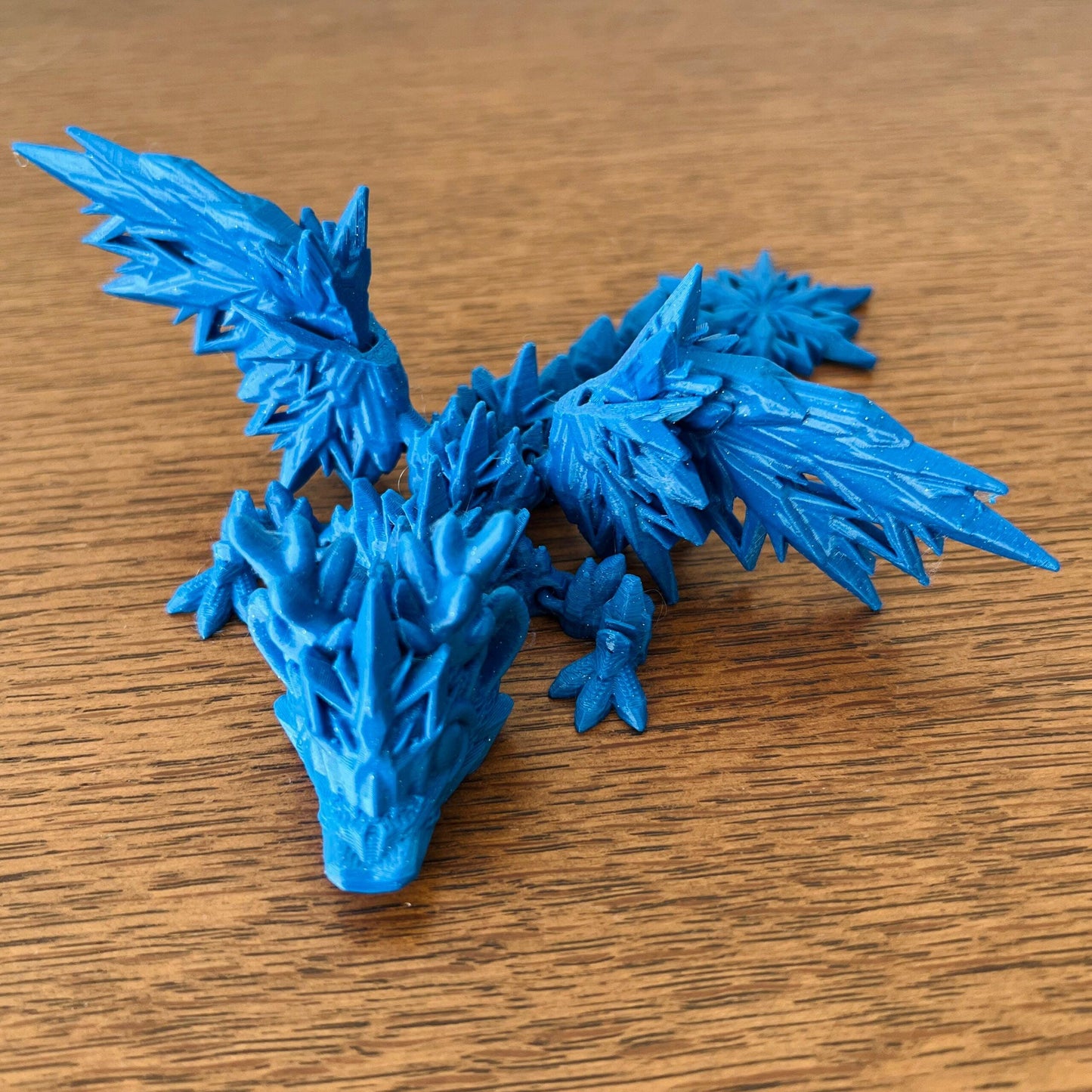 Frosty blue dragon with intricate icy wings, capturing the essence of winter and dragon lore in a whimsical design.