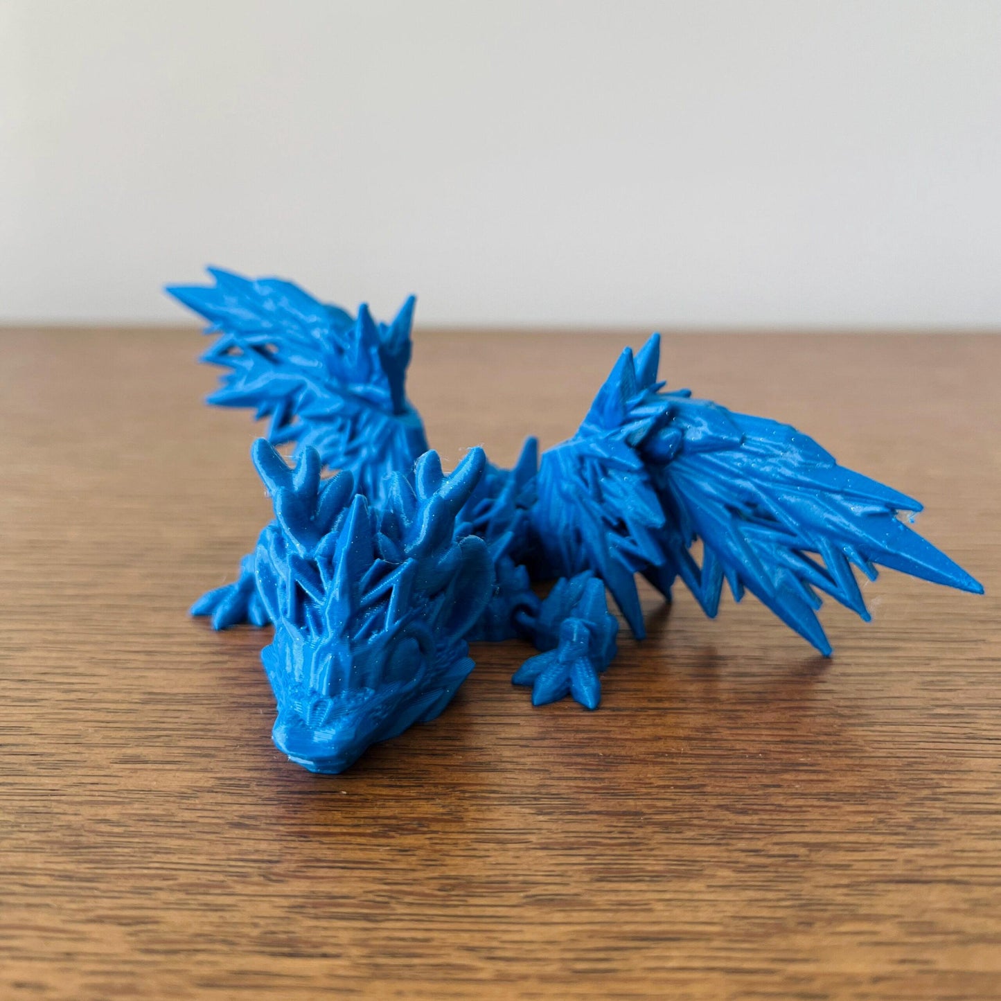 Frosty blue dragon with icy wing details, embodying the magic of a winter wonderland. Perfect for dragon lovers.