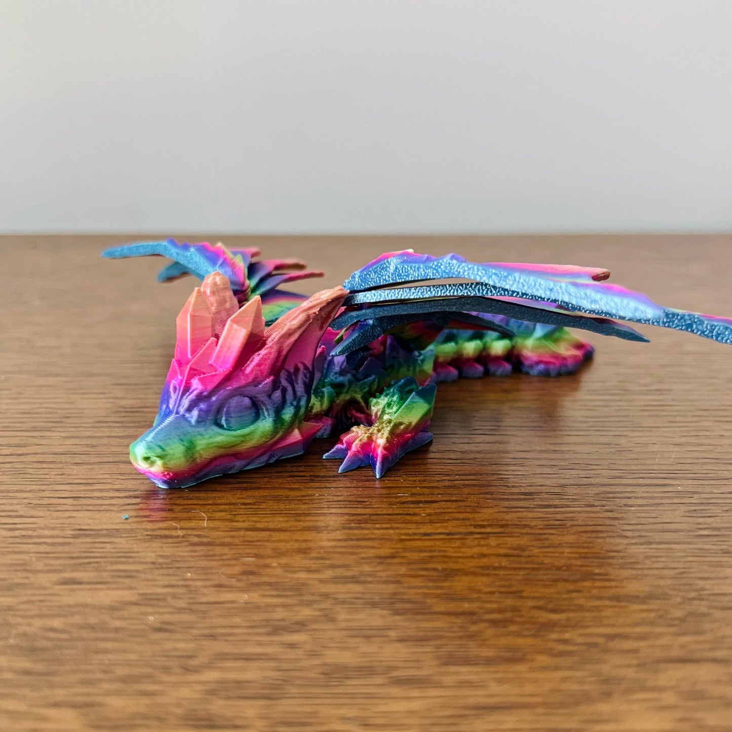 Colorful dragon figurine with crystal-like details and elegant wings, showcasing vibrant hues and intricate features.