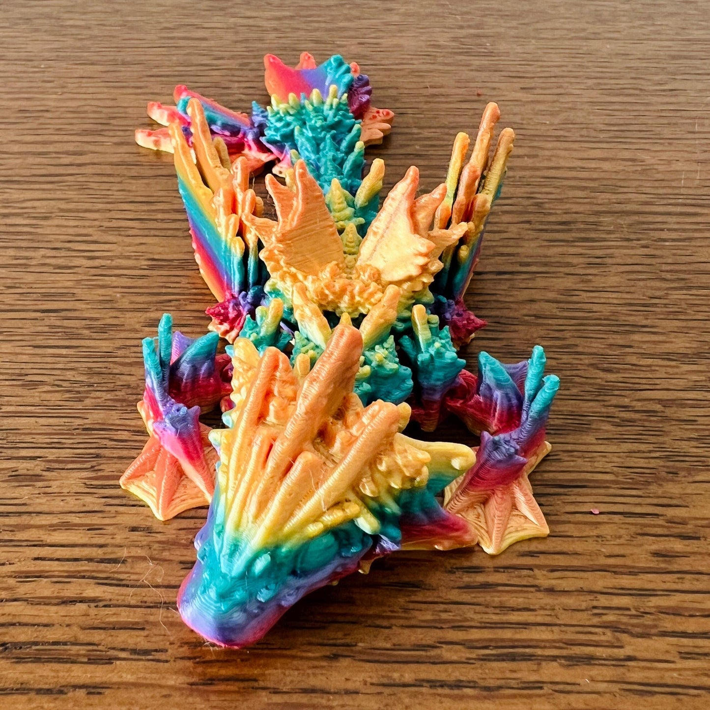 Vibrant Ocean Wing Dragon Tadling with wave-like details in hues of blue, orange, and yellow, evoking an aquatic feel.