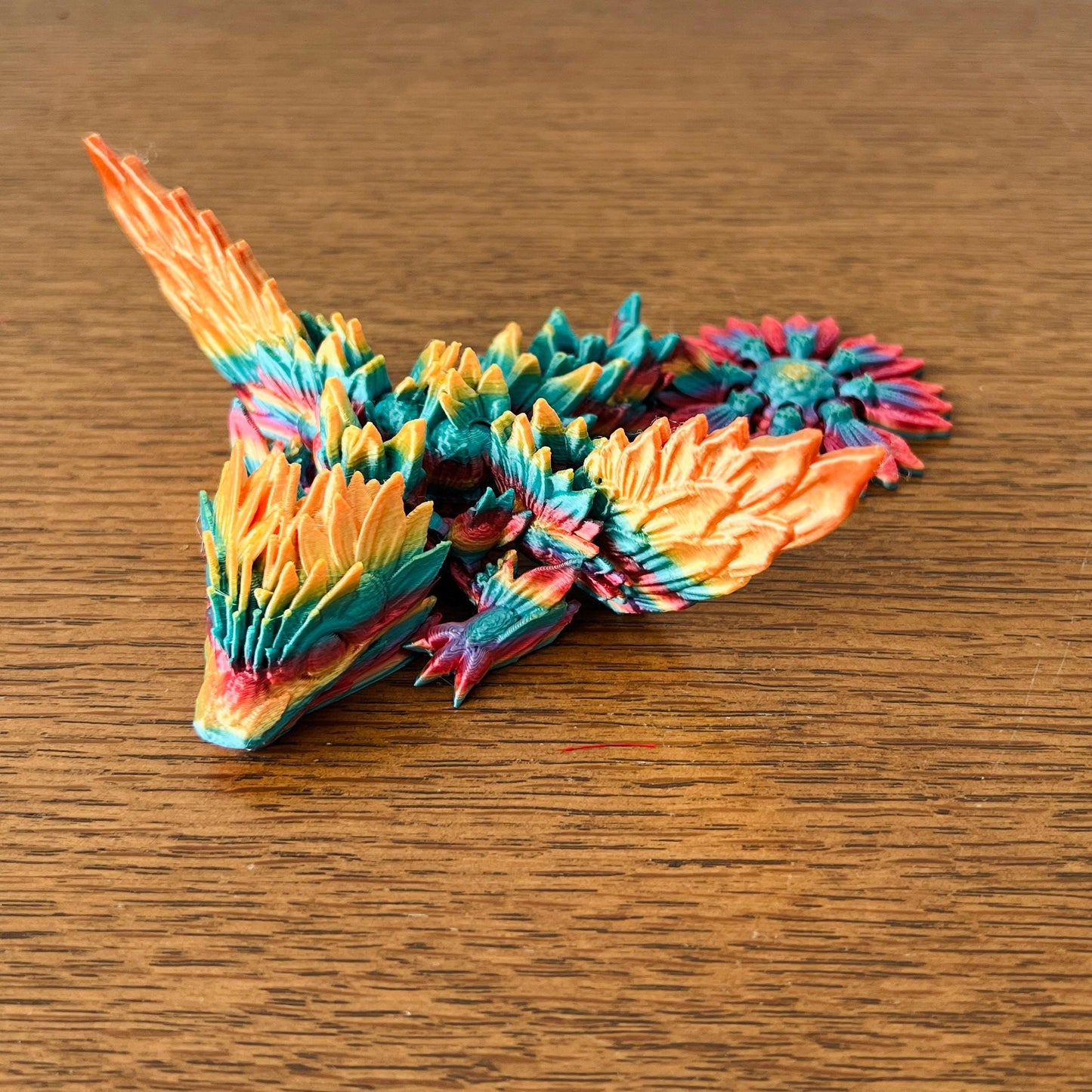 Colorful dragon with delicate wings and sunflower-inspired details, showcasing vibrant yellows, oranges, and greens.