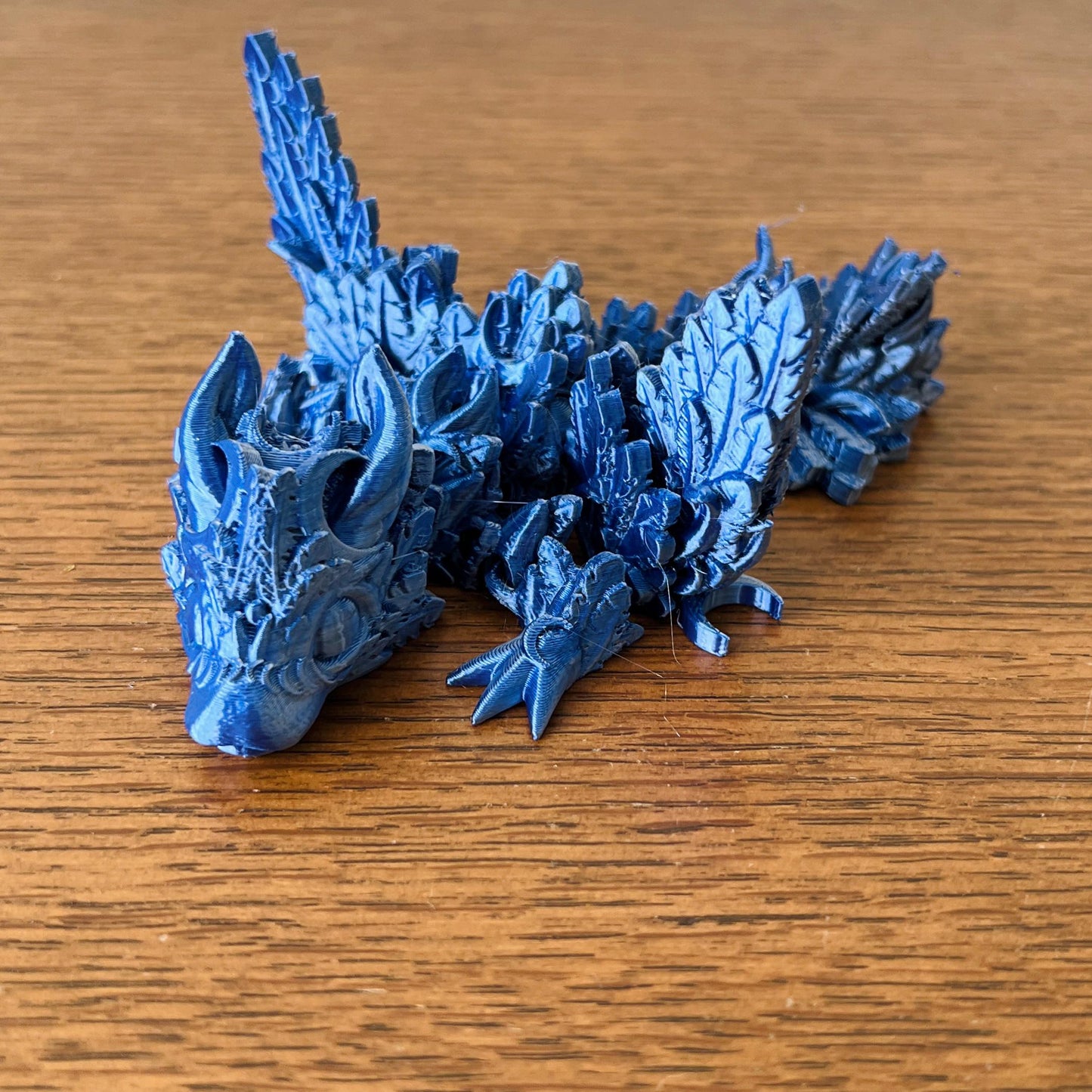 A blue dragon with intricate lunar details and elegant wings, embodying the mystique of the night sky.
