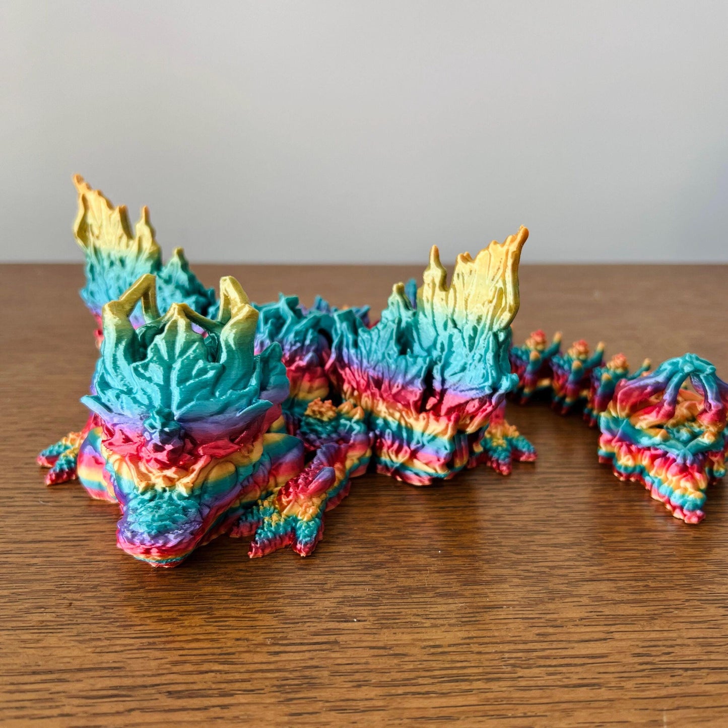 Vibrant dragon with colorful, leaf-inspired wings, showcasing intricate autumn textures and details.