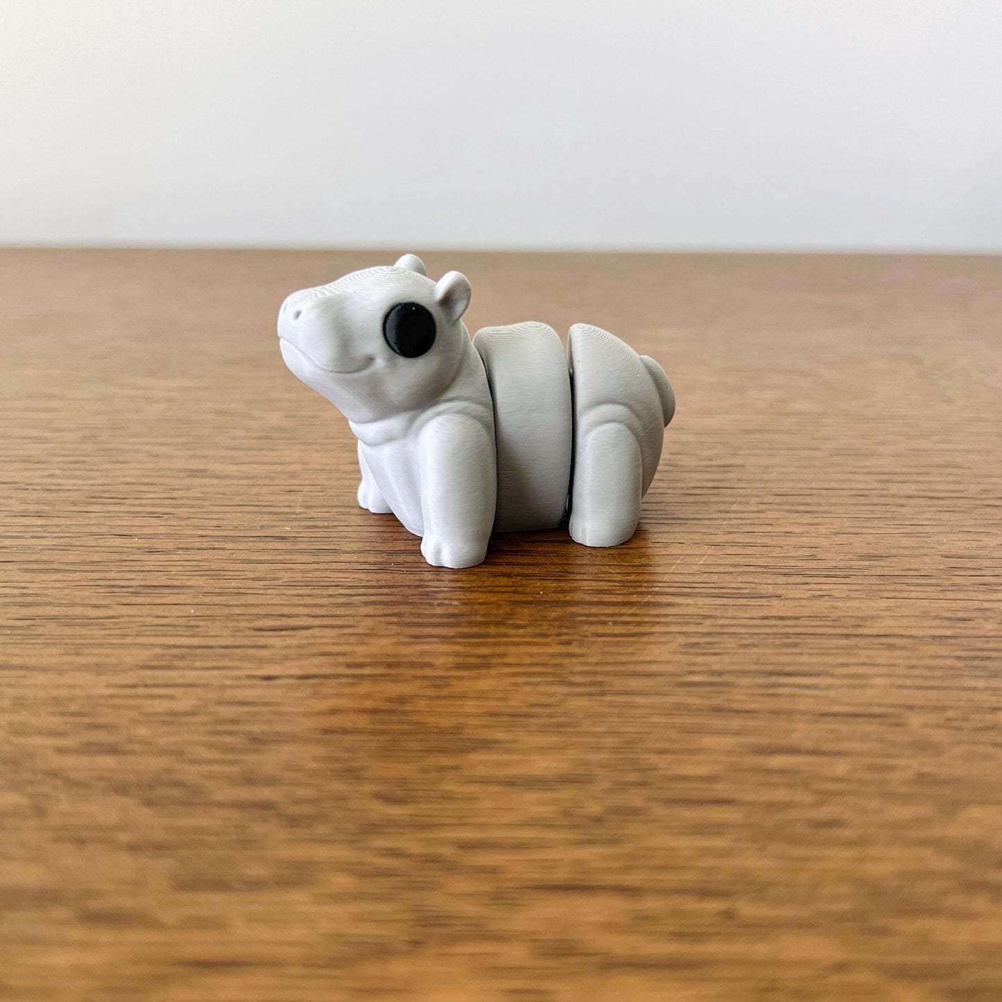 Adorable 3D printed mini hippo in soft gray with articulated body, perfect for sensory play and delightful collectibles.