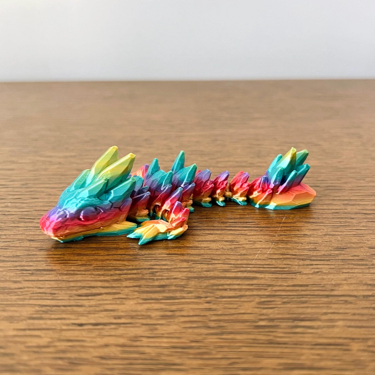 Colorful 3D printed dragon with a flexible body and gemstone-like details, perfect for sensory play and collecting.