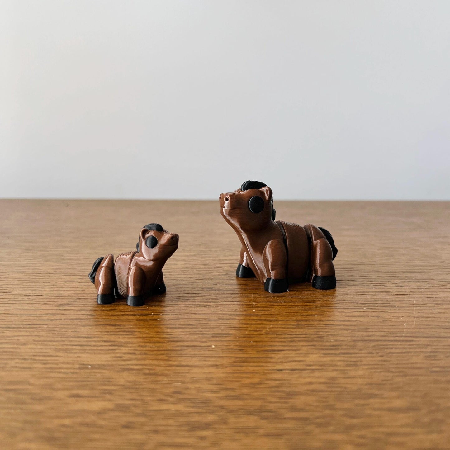 Articulated mini horses in brown with black accents, perfect for sensory stimulation and charming collectibles.