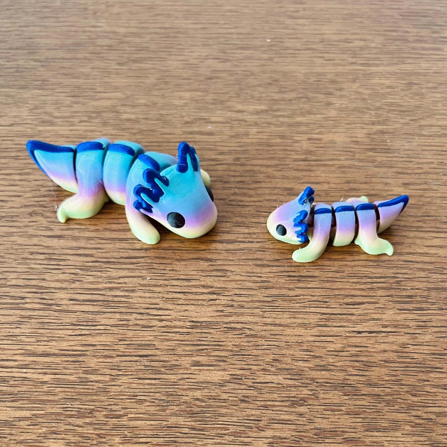 Colorful rainbow axolotls in various sizes with articulated bodies, perfect for sensory play and stress relief.