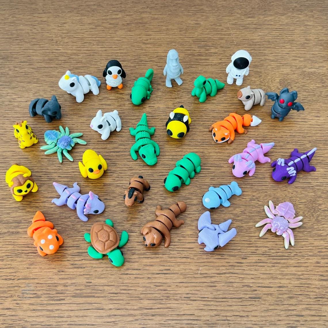 Colorful assortment of 10 micro-sized, articulated fidget toys featuring animals, food, and seasonal themes.