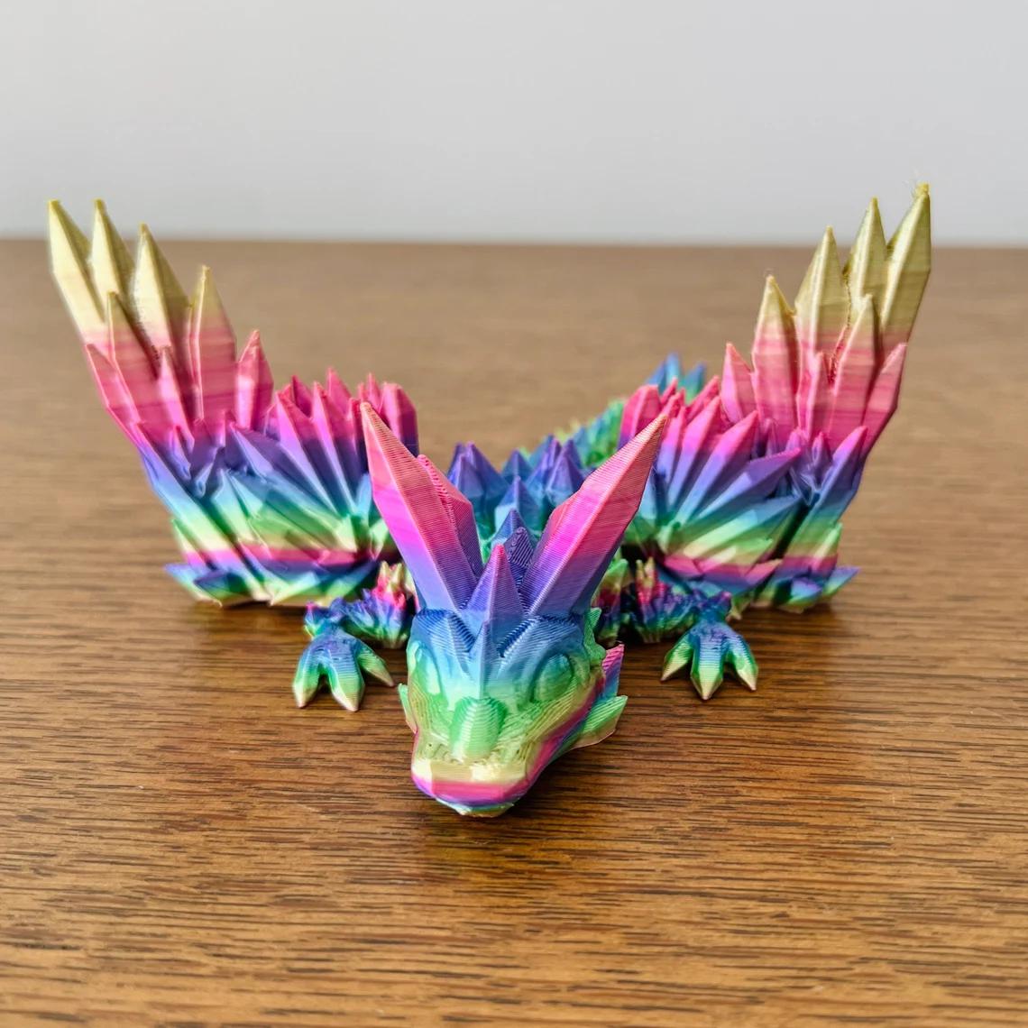 A vibrant 3D-printed dragon with crystal-like wings in rainbow colors, perfect for fantasy decor and collections.