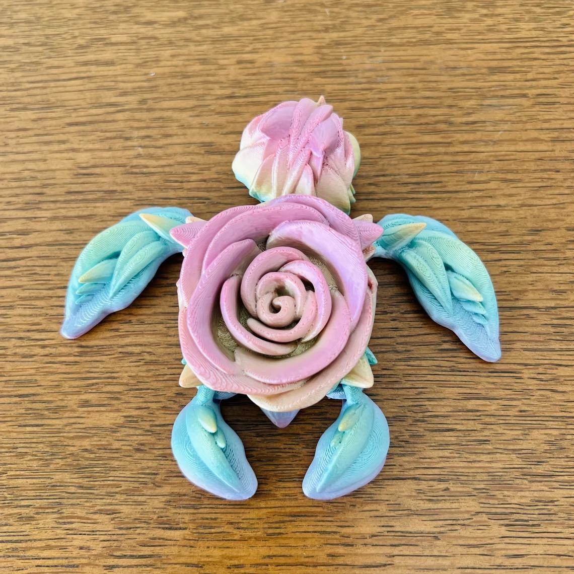 3D-printed turtle with a pink rose as its shell, featuring vibrant colors and leaf-like flippers, perfect for decor.
