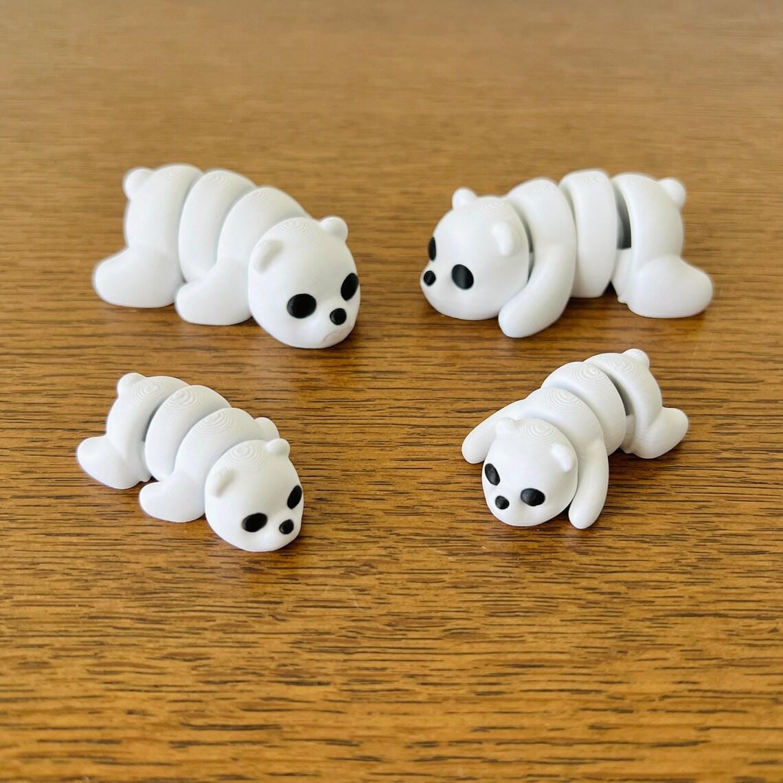 Four adorable articulated white bears with black eyes, posed on a wooden surface, showcasing playful charm.