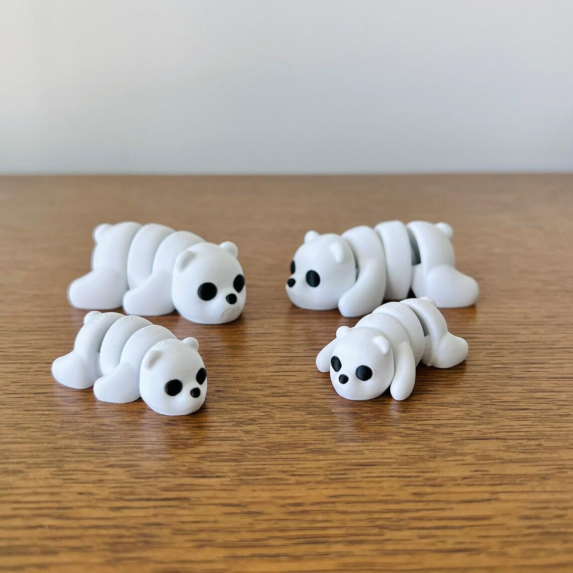 Four adorable articulated white bears with black eyes, showcasing various poses on a wooden surface.