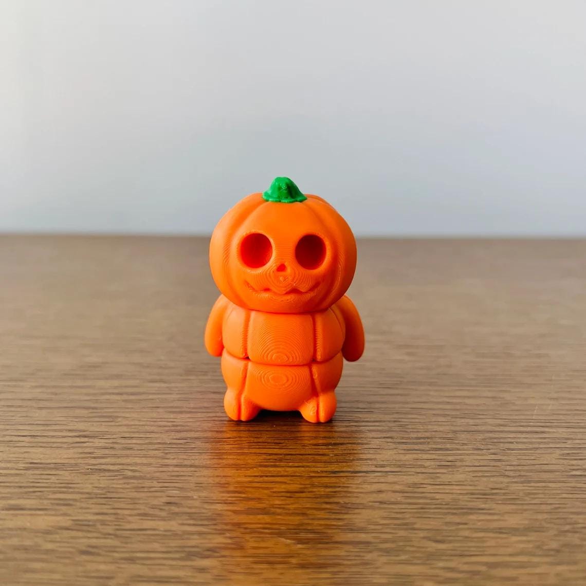 Charming orange pumpkin figure with a playful smile and green stem, perfect for festive decor and sensory play.
