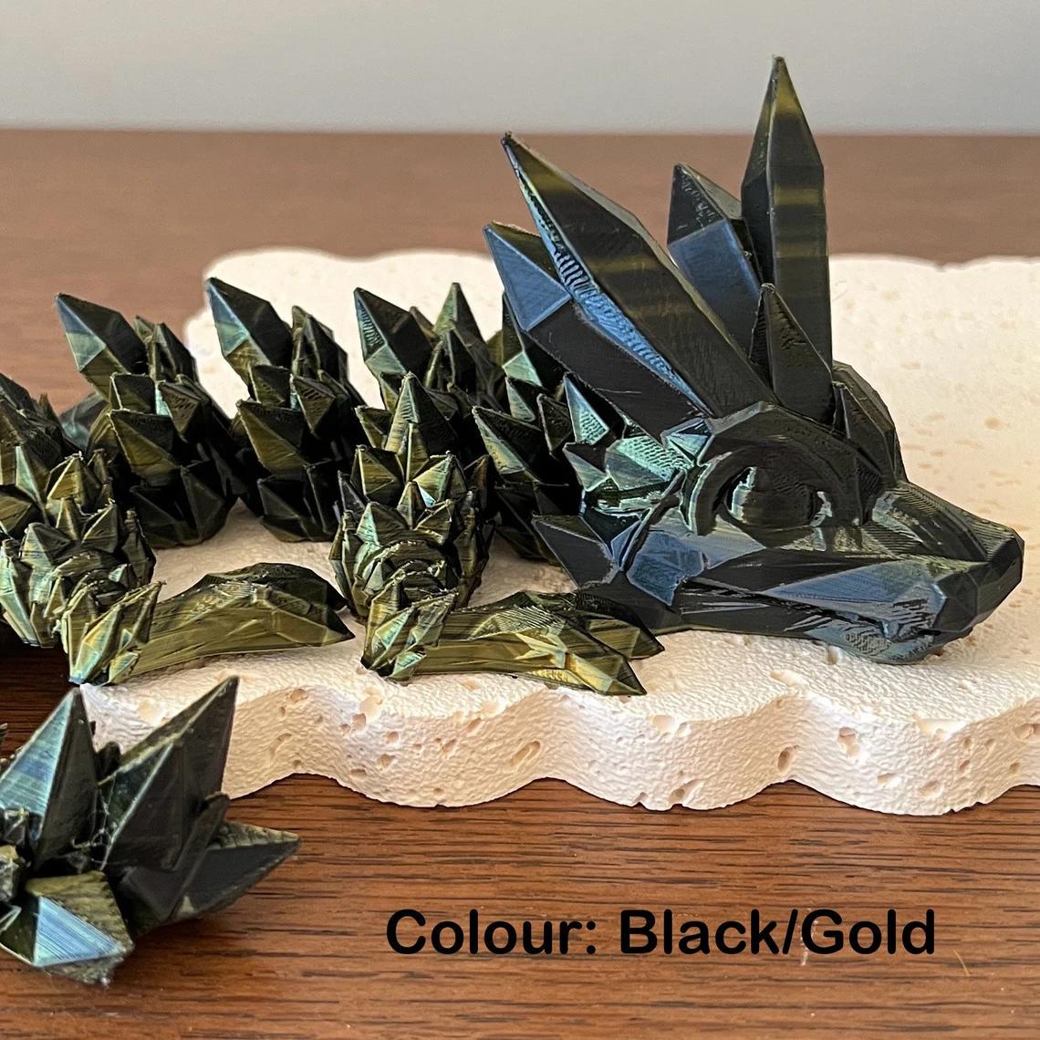 A stunning black and gold crystal dragon figurine with intricate spikes, resting on a textured surface.