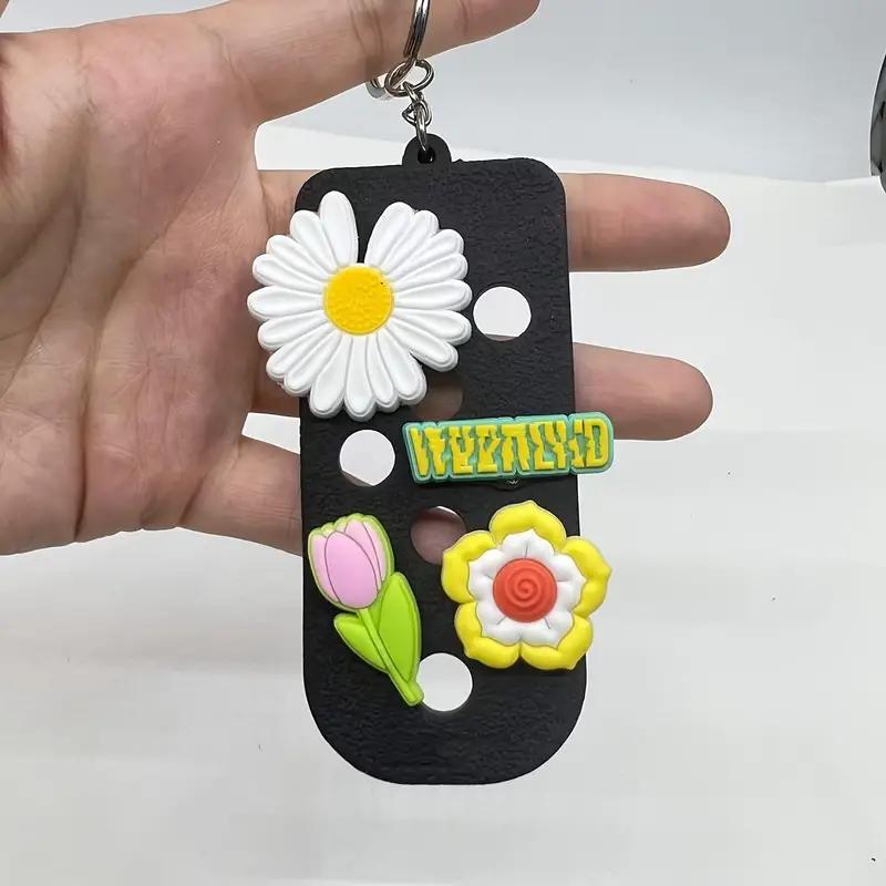 Colorful shoe charm keychain with floral designs and "WEIRD" text, perfect for personalizing bags or luggage.