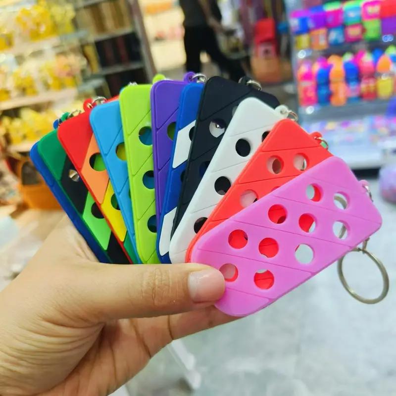 Colorful keychains in various shapes, perfect for personalizing with your favorite charms, held in a hand.