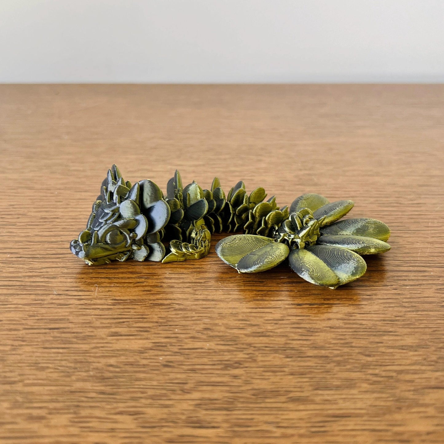 A charming wingless dragon with clover-inspired details, showcasing intricate textures in green and dark tones.
