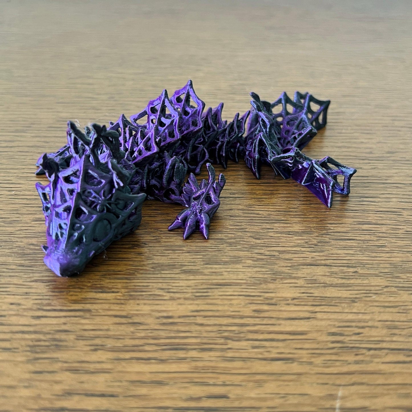 Articulated dragon figure in black and purple, featuring intricate details for a striking sensory experience.