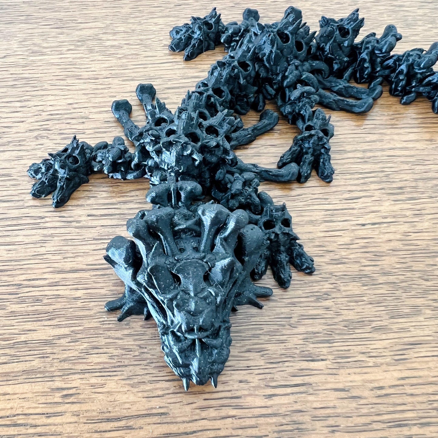 A hollow dragon with skull-like features, intricately detailed and exuding a mysterious charm on a wooden surface.