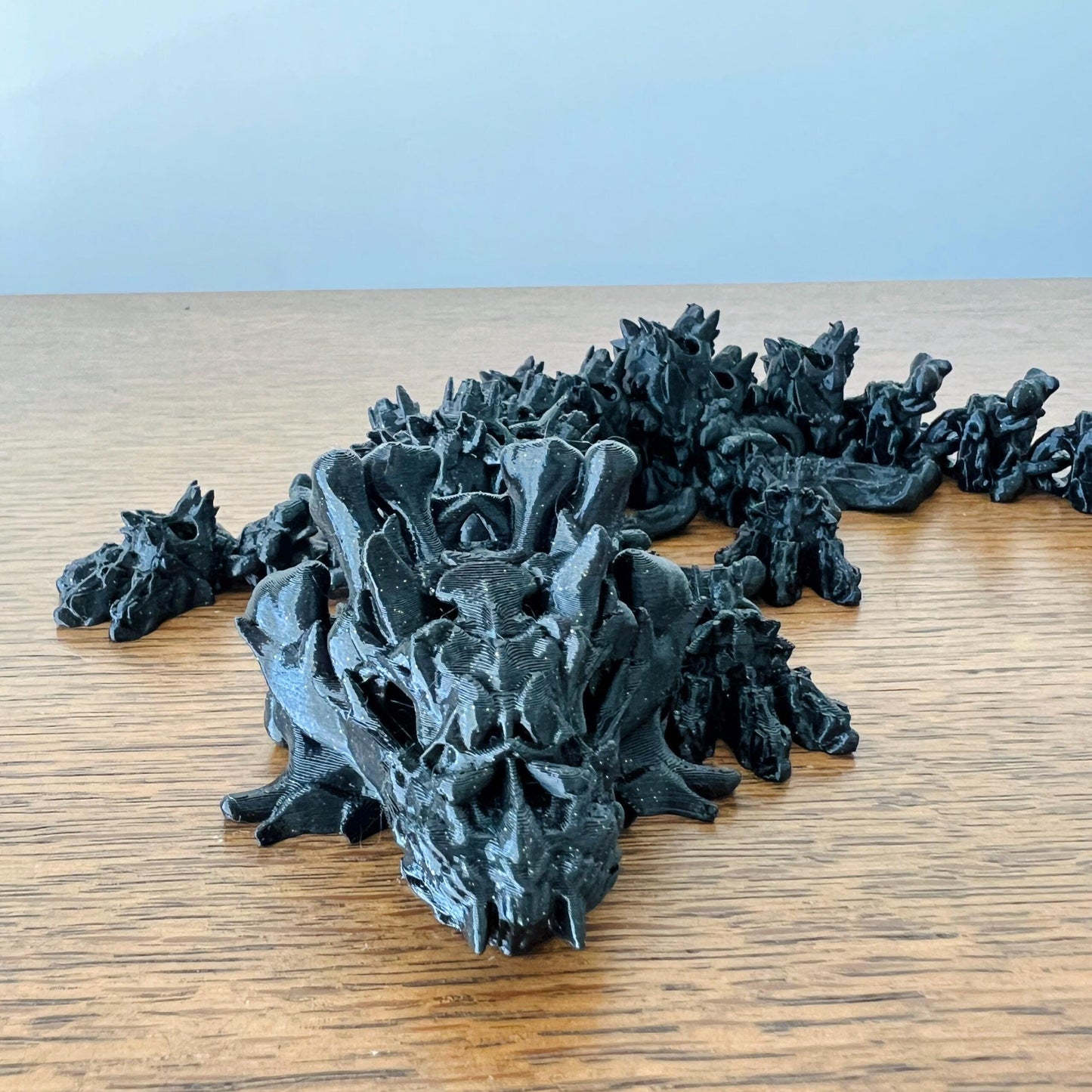 A hollow dragon with intricate skull-like features, exuding an eerie charm, rests on a wooden surface.