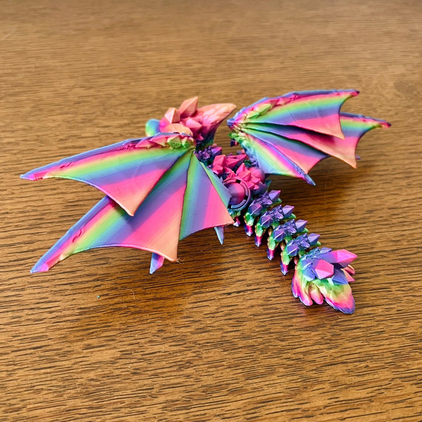 Colorful dragon with crystal-like details and vibrant wings, showcasing a blend of pink, purple, and green hues.