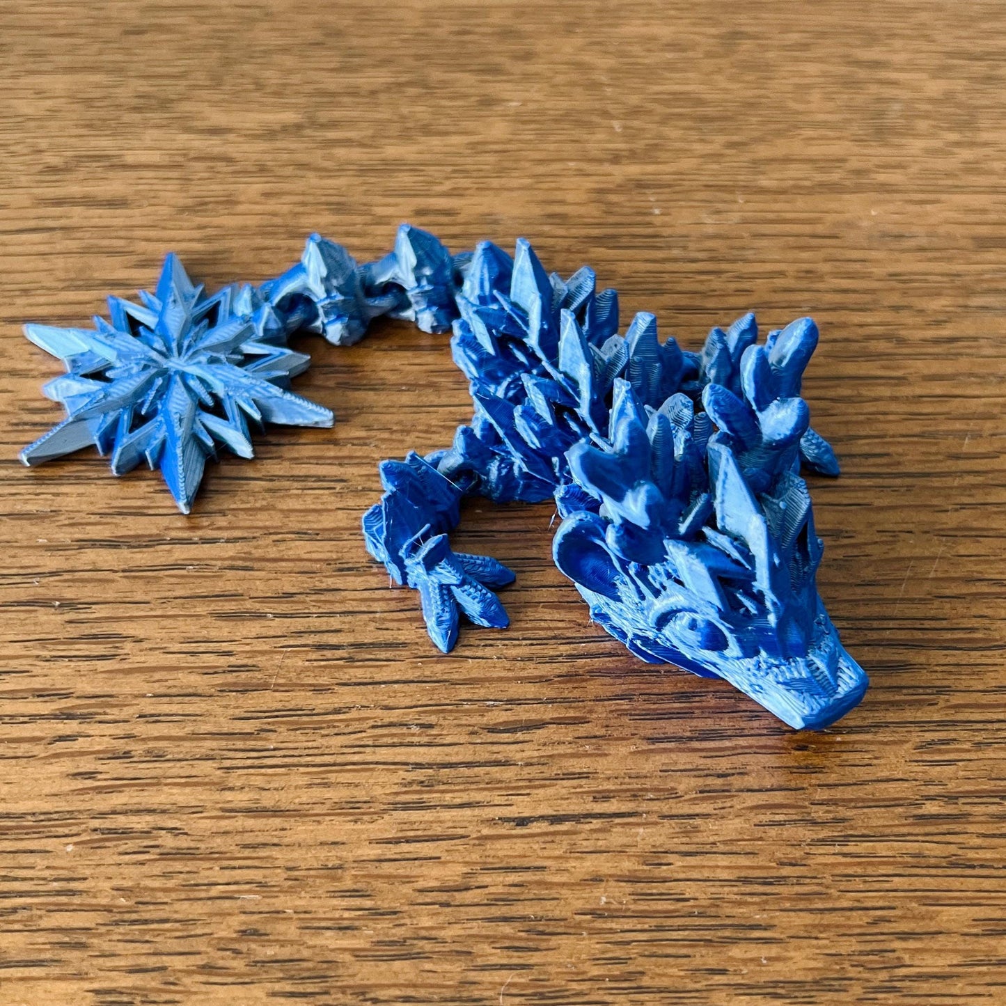 A wingless blue dragon with icy details, adorned with sharp, crystalline shapes, embodies the essence of winter.