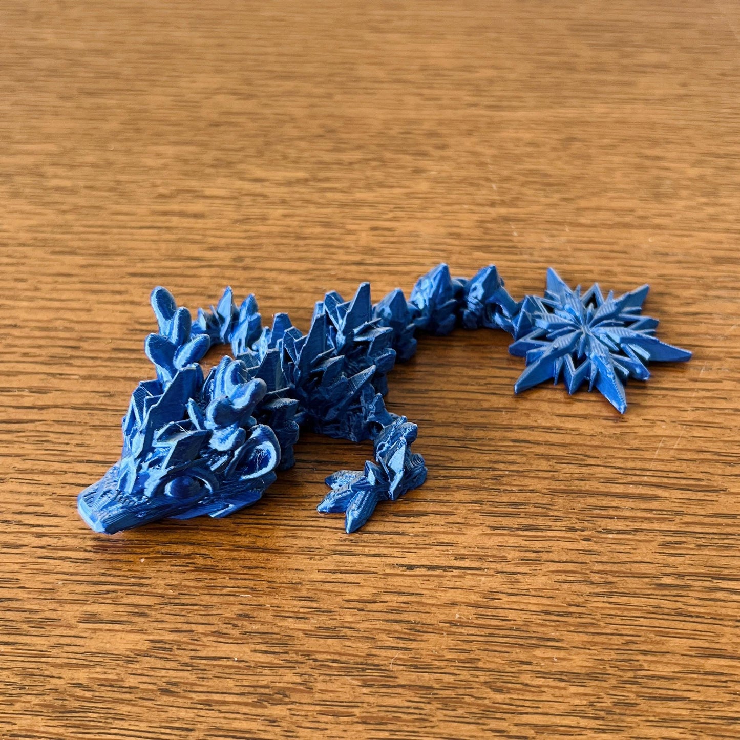 Winter Dragon Tadling in icy blue, featuring intricate spikes and star-like details, embodying a frosty elegance.