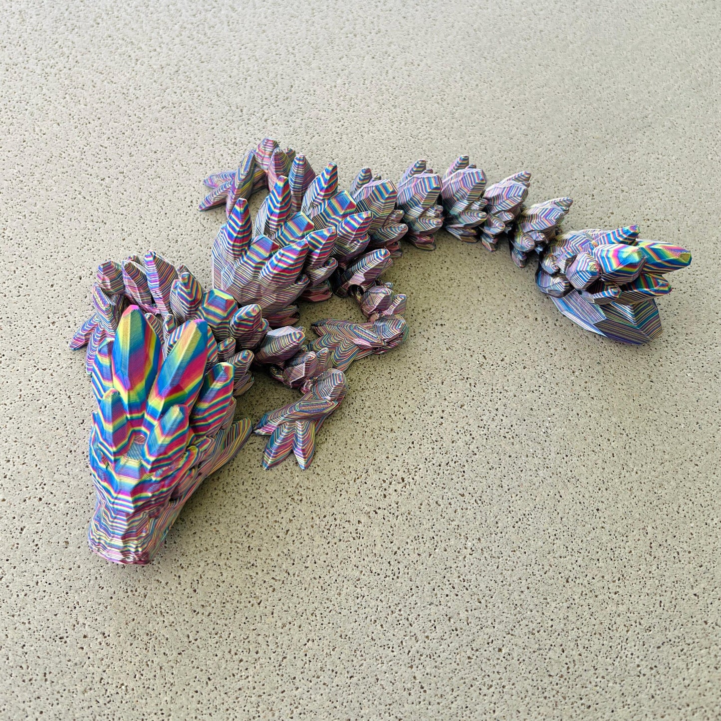 Colorful dragon sculpture with intricate details, showcasing a dazzling array of gemstone-inspired hues and patterns.
